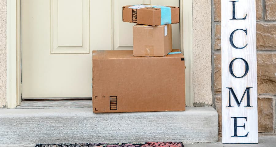 Boxes by the door of a residence with a welcome sign in Louisville